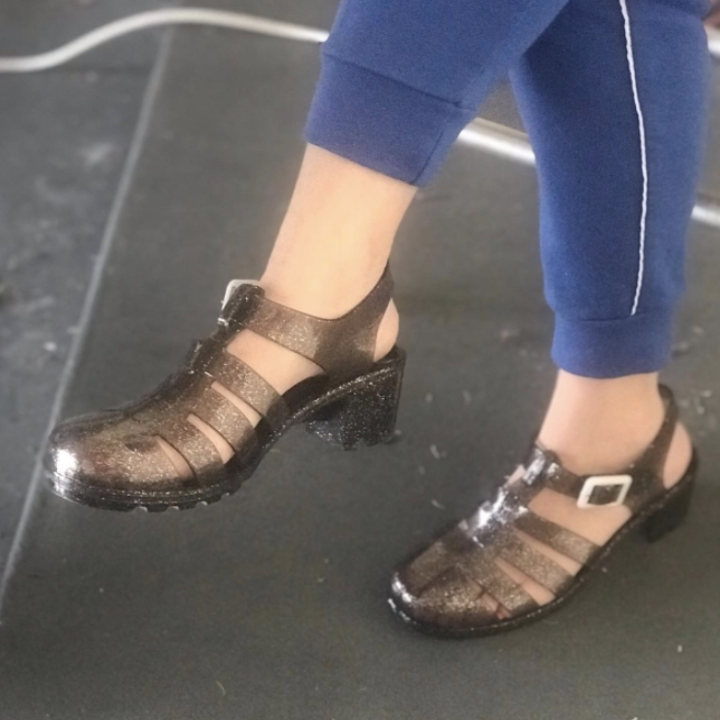a reviewer in the black glittery heeled jelly shoes