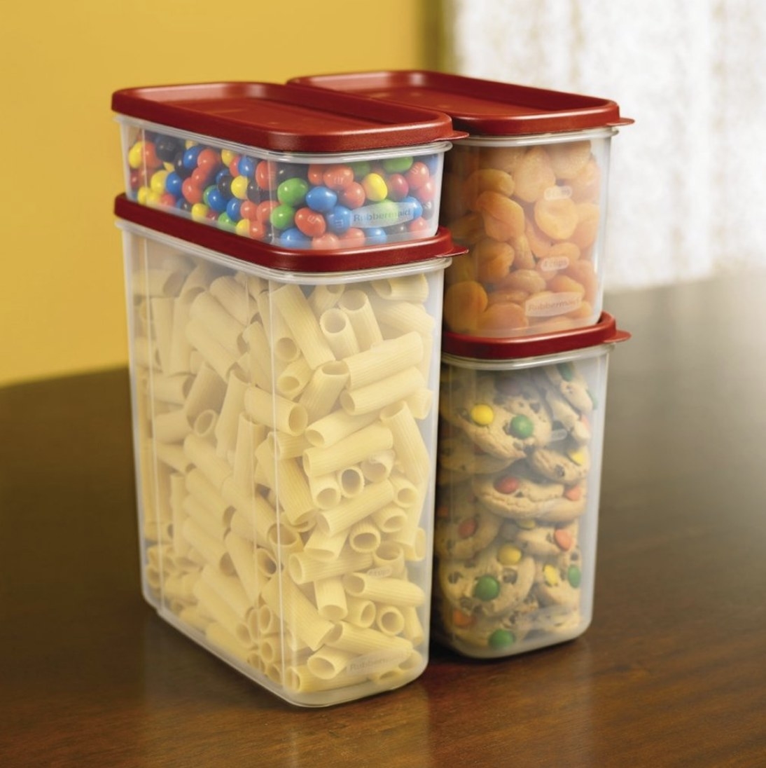 Four clear containers of varying sizes stacked with food inside