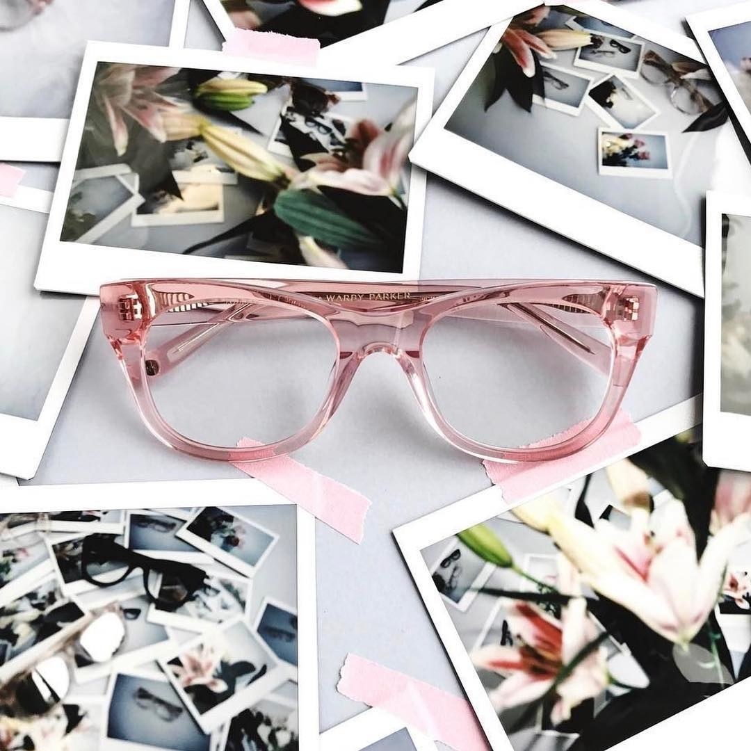 The glasses on a scrapbook filled with instant photos