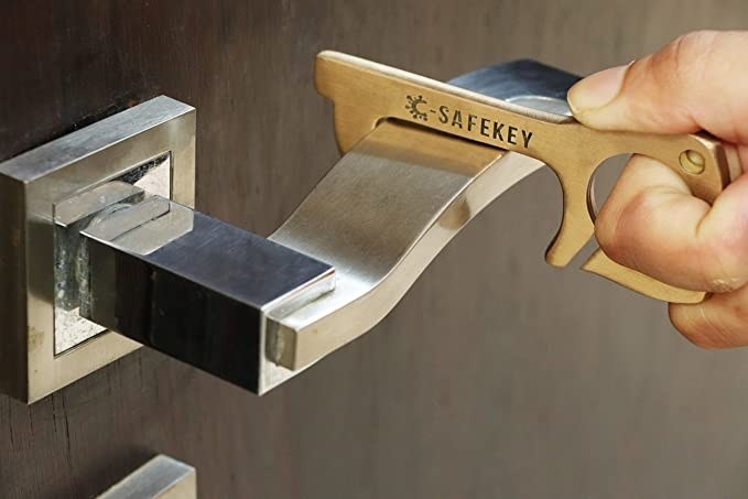 Door handle being pulled with the brass key opener.