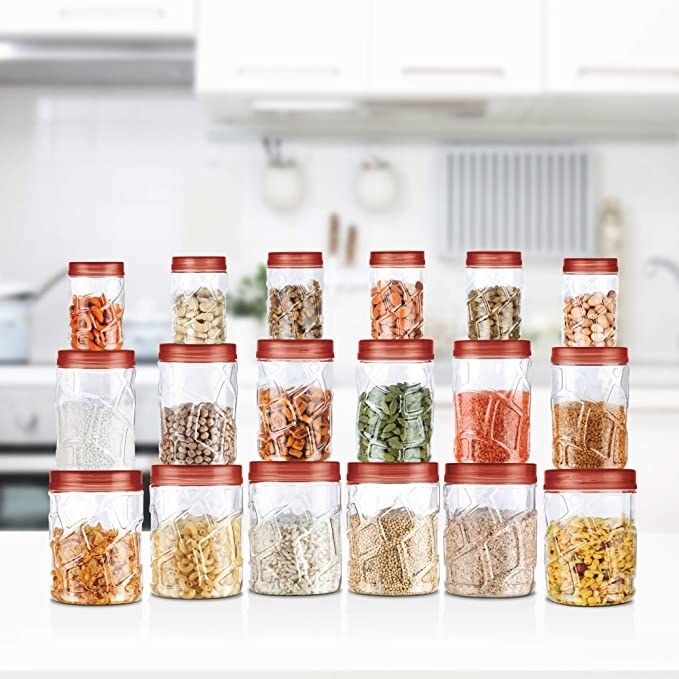 18 jars of different sizes with nuts, pulses and grains in them.