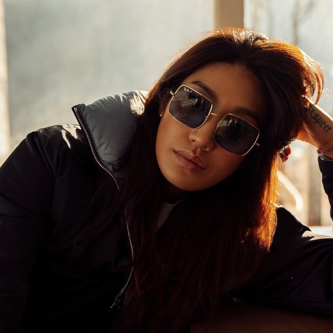 A person wearing the square sunglasses with a puffy jacket