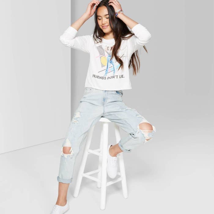 Model in distressed mom-jeans and sweatshirt 