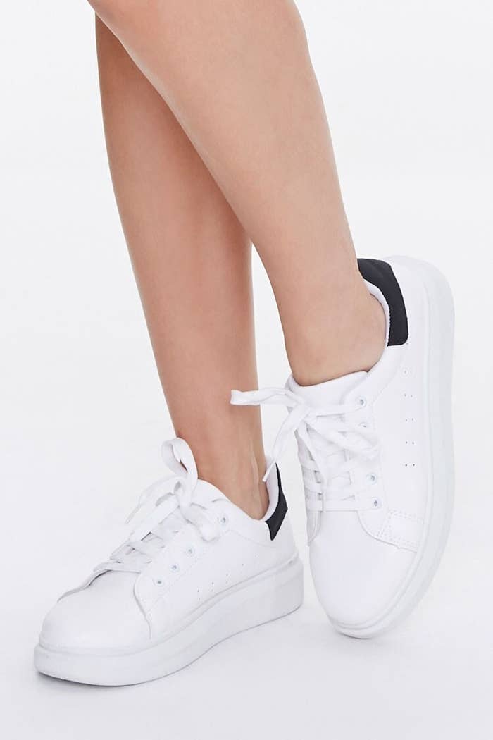 The white lace-up sneakers with thick platform sole and black coloring on the heels