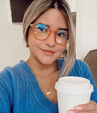 A person wearing the glasses and holding a coffee