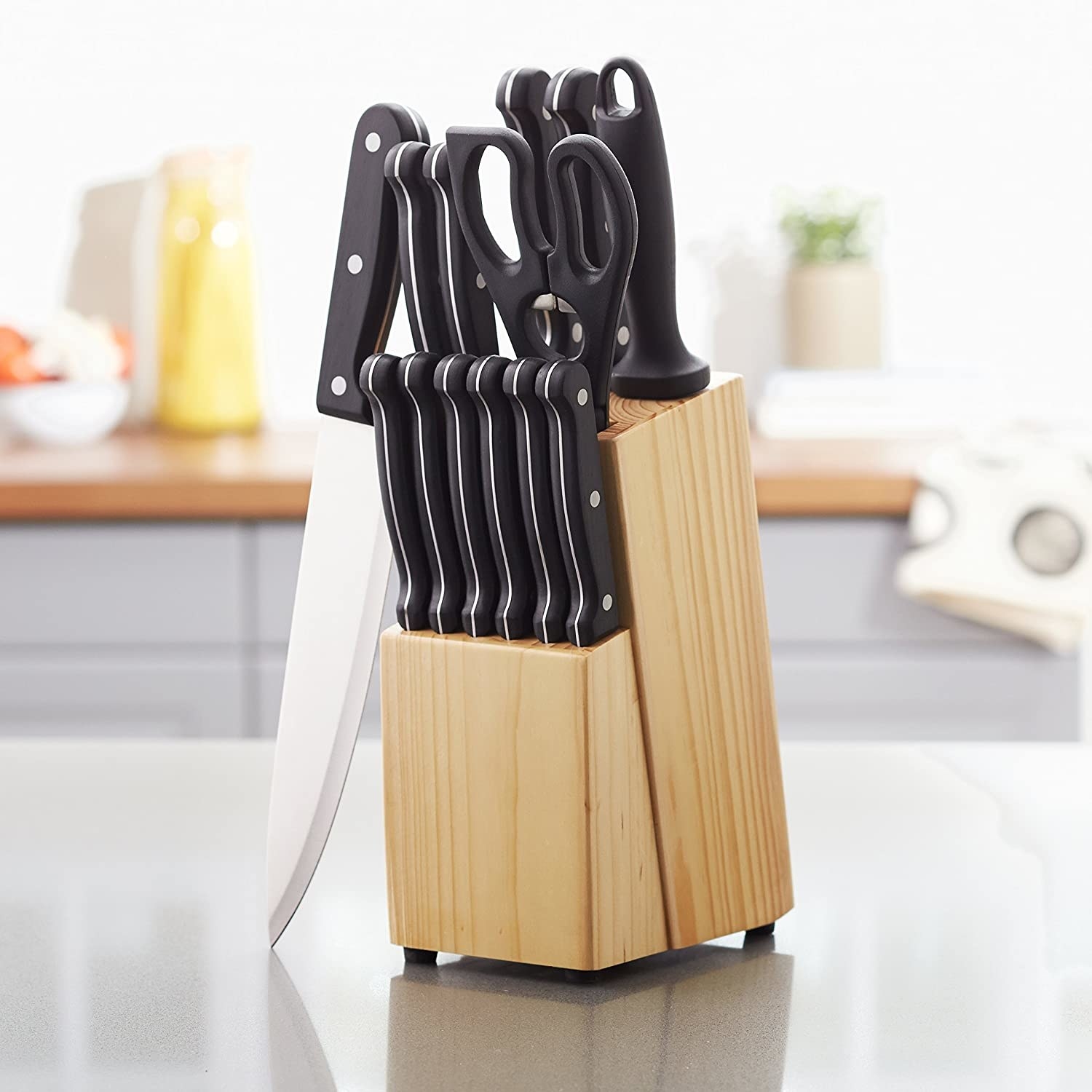 The knife set in a pine wood block on a kitchen counter