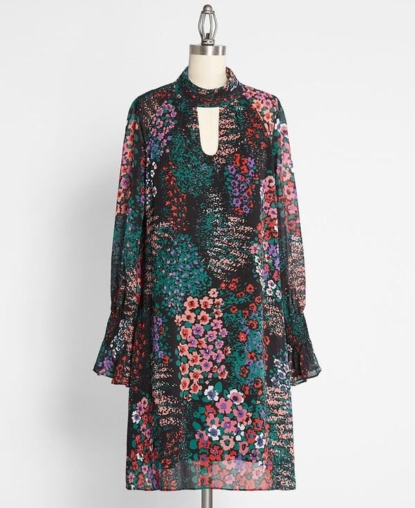 The black, purple, pink, white, and green floral shift dress on a mannequin