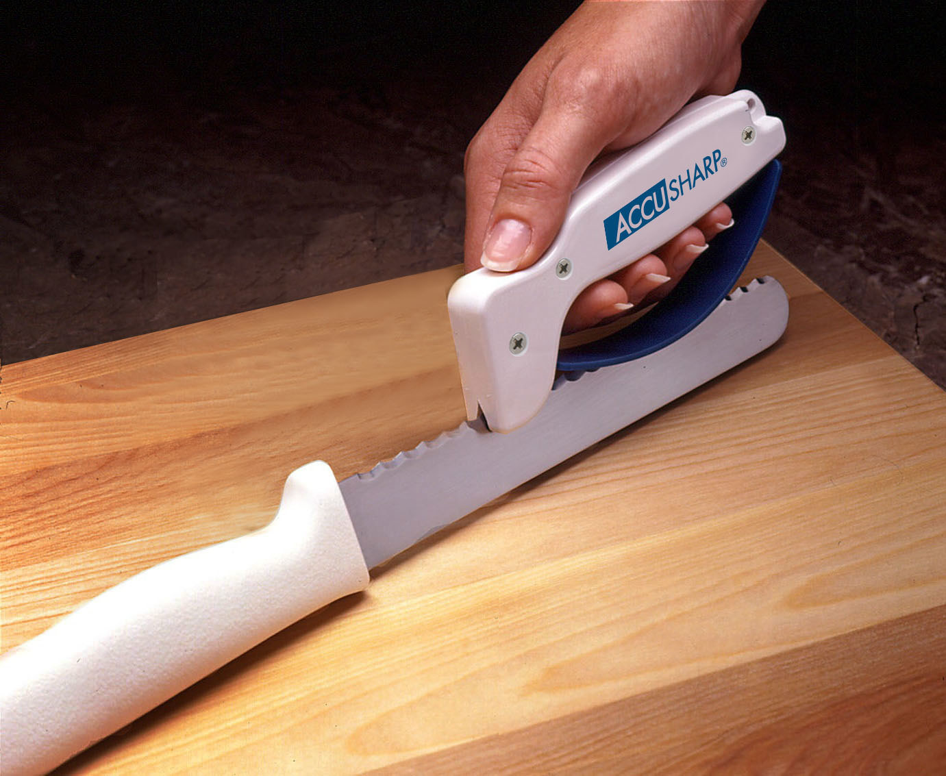 person using accusharp knife sharpener to sharpen a serrated knife