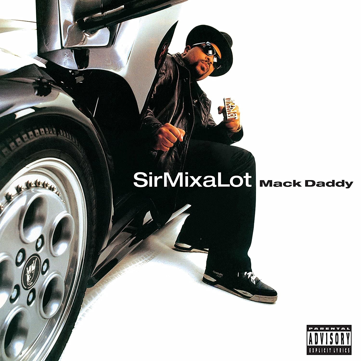 album cover of Mack Daddy showing Sir Mix-a-Lot sitting with his legs out of the seat of a gull-winged car