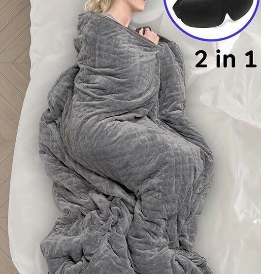 a model sleeping while wrapped up in a grey gravity blanket