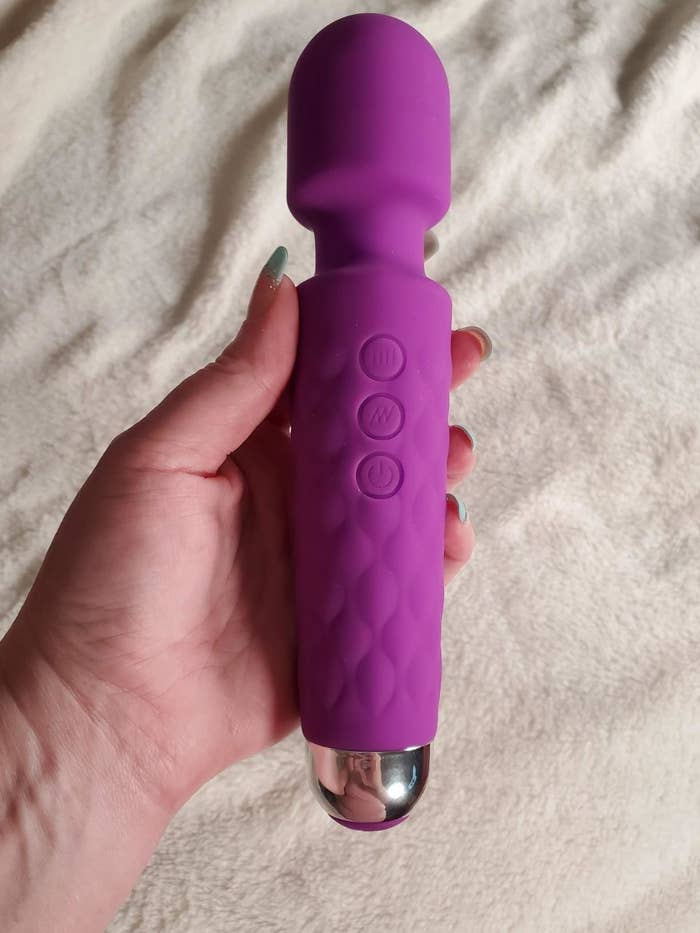 A reviewer holding the purple toy