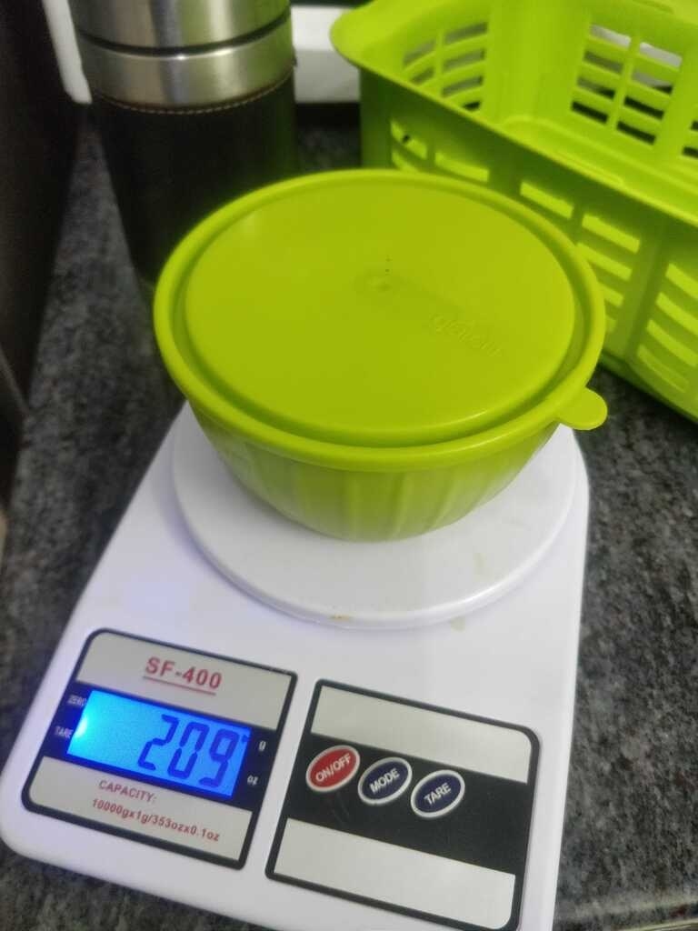 Digital scale measuring a container weighing 209grams.