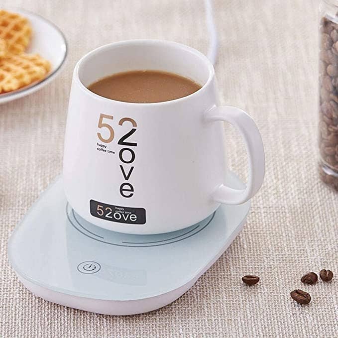 Electric mug warmer with some tea or coffee in it.