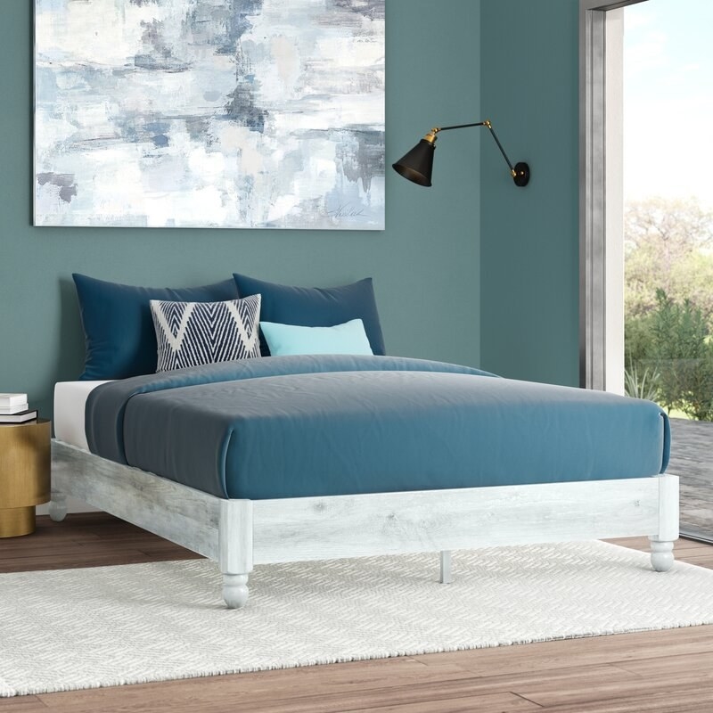 A white wooden bed frame without headboard