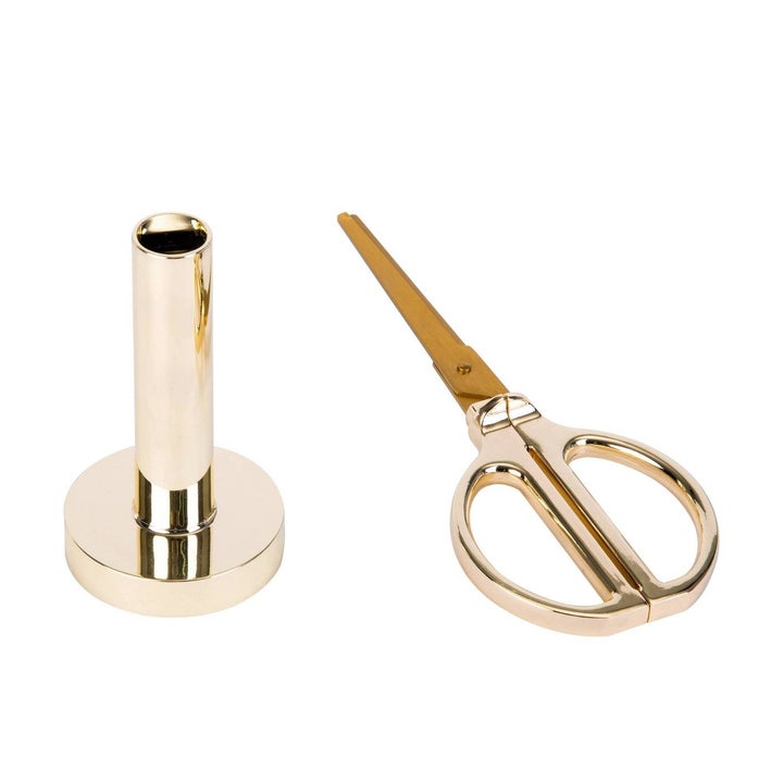 The scissors and the stand, which is a hollow tube mounted on a rose gold circle