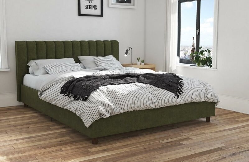 A green upholstered bed frame with vertical tufted headboard
