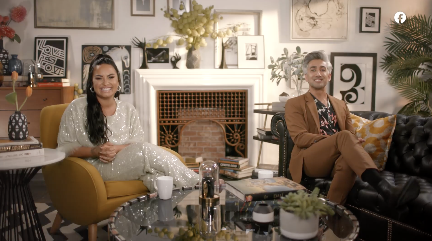 Demi and Tan smiling on couches