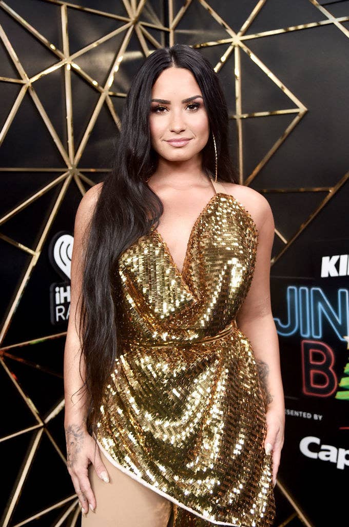 Demi wearing a shimmering, metallic asymmetrical dress