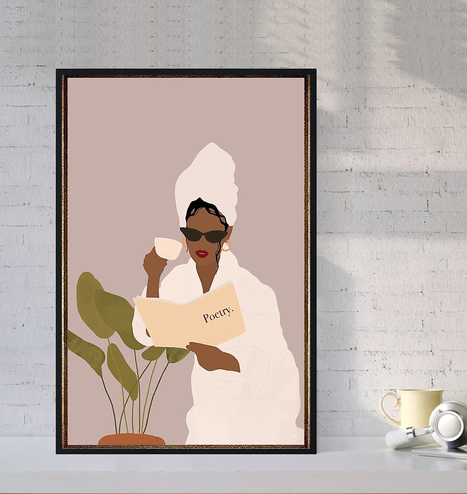 A print of a woman in red lipstick, sunglasses, a robe, and a hair towel drinking coffee and reading a book of poetry while sitting near a plant