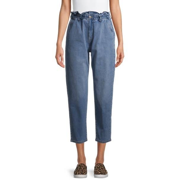 Model in mom jeans with paperbag waist and leopard sneakers