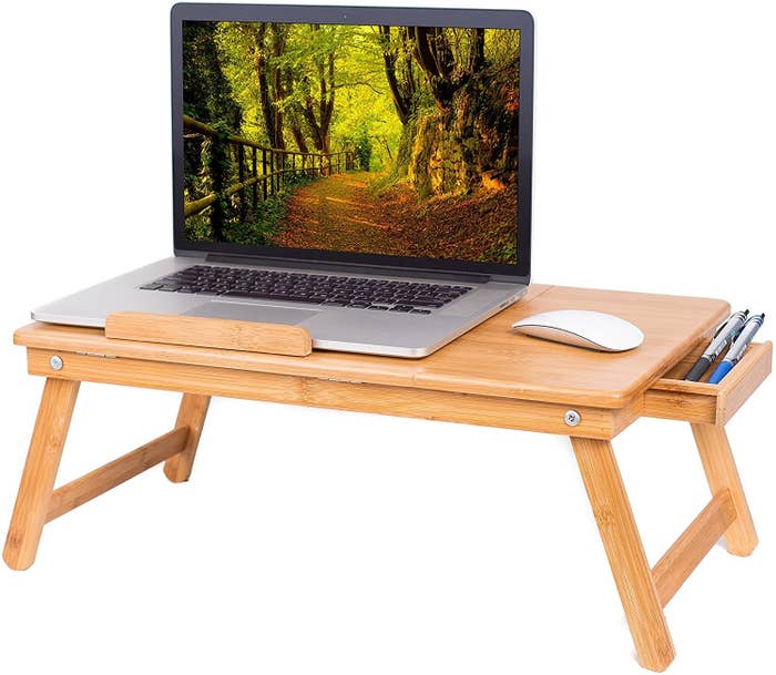 The lap desk has space for a laptop and a mouse. It also has a drawer for writing utensils