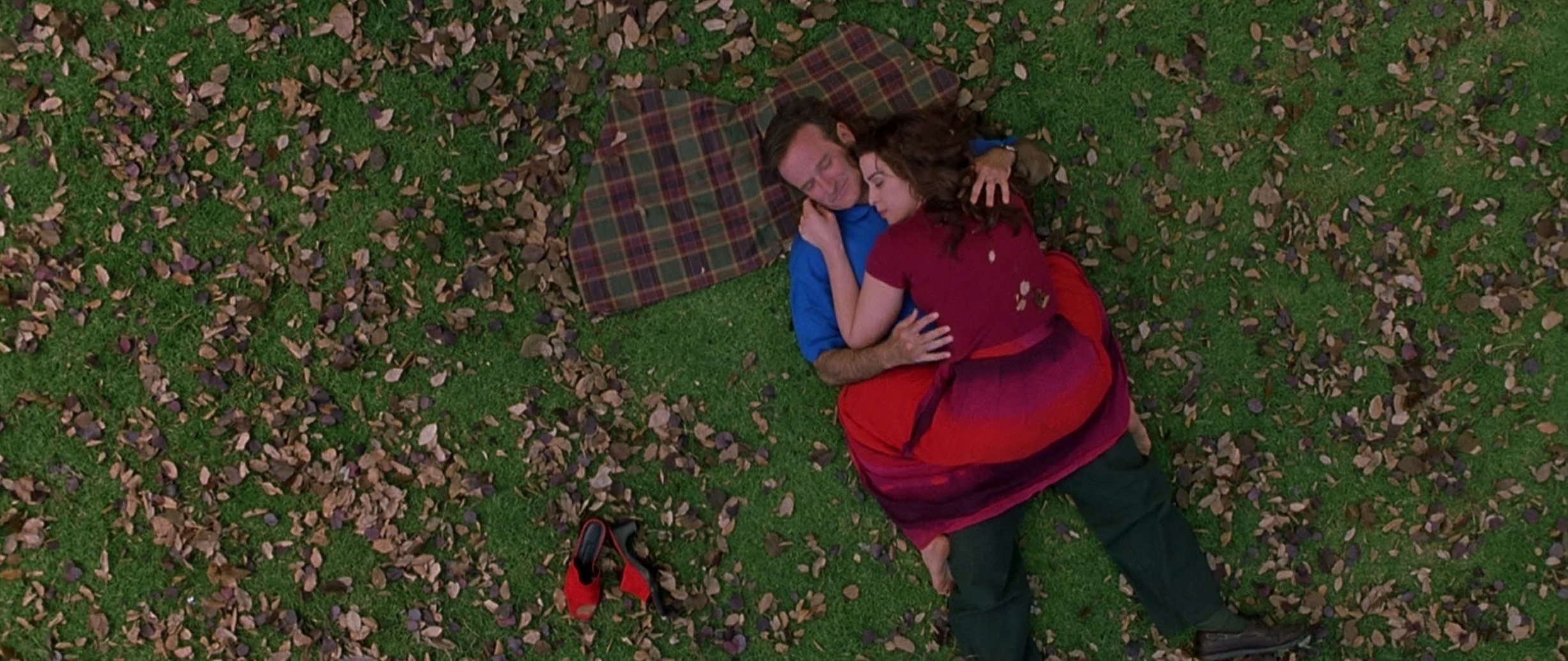 A couple laying on the grass hugging