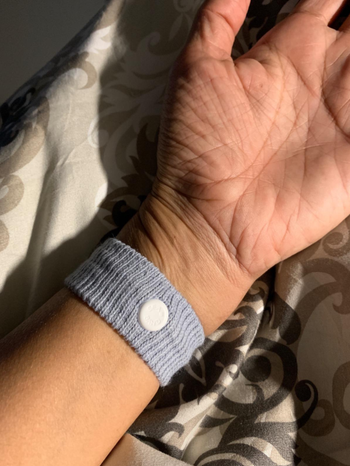 A reviewer wearing the gray anti-nausea wristband