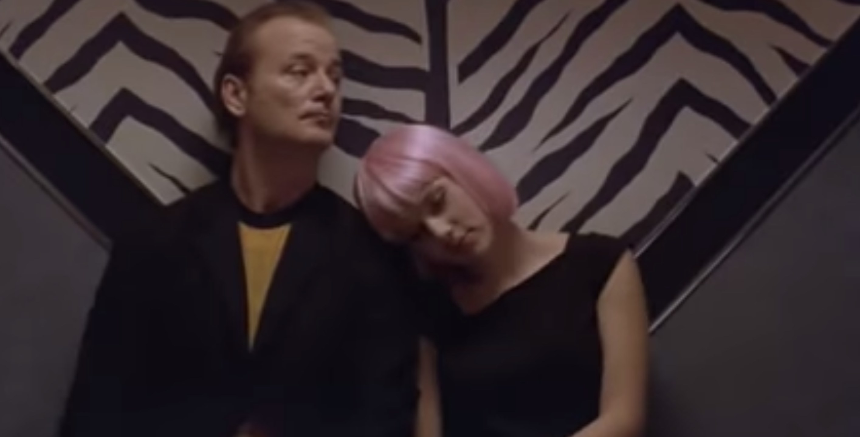 A man played by Bill Murray is with a girl in a pink wig played by Scarlett Johansson