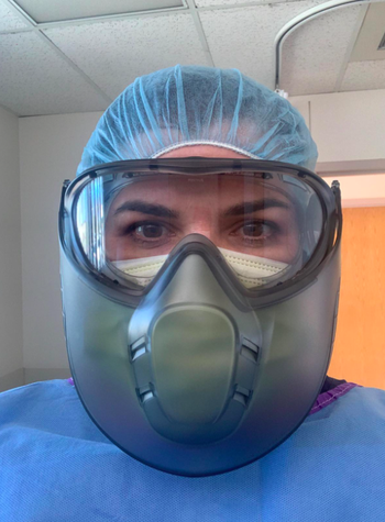A healthcare professional showing their protective eye wear is fog-free even while wearing a mask and protective face shield