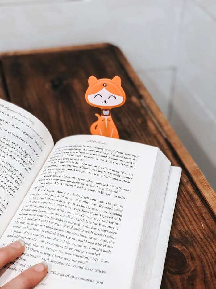flat cat bookmark with light on forehead slipped into a book