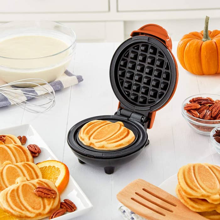 small waffle iron with pumpkin shaped treat inside