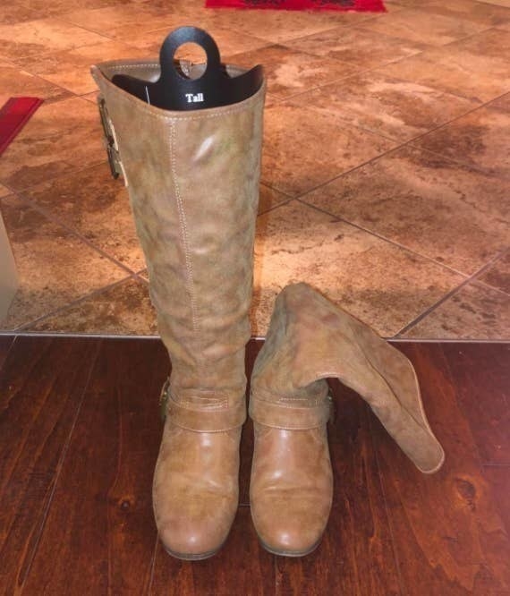 On the left, a tall boot standing up straight with the shaper inside of it, and on the right, the other boot of the pair, leaning down, because it doesn&#x27;t have a shaper inside of it