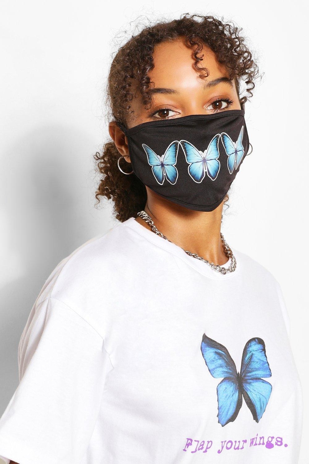 model wears black mask with three blue butterflies 