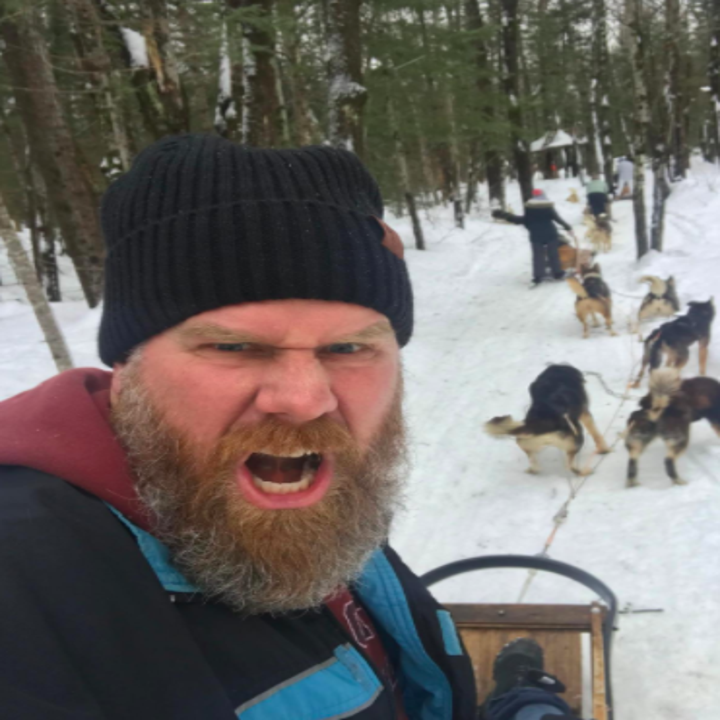 reviewer wearing OZERO beanie in black while dogsledding in Canada 