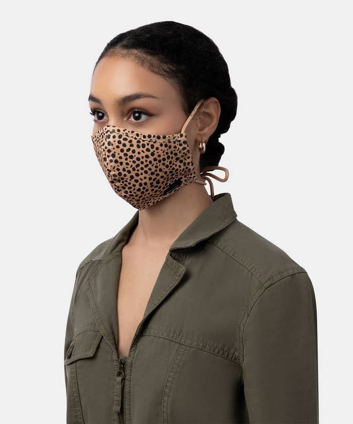 model wears tan mask with black spots with tie back