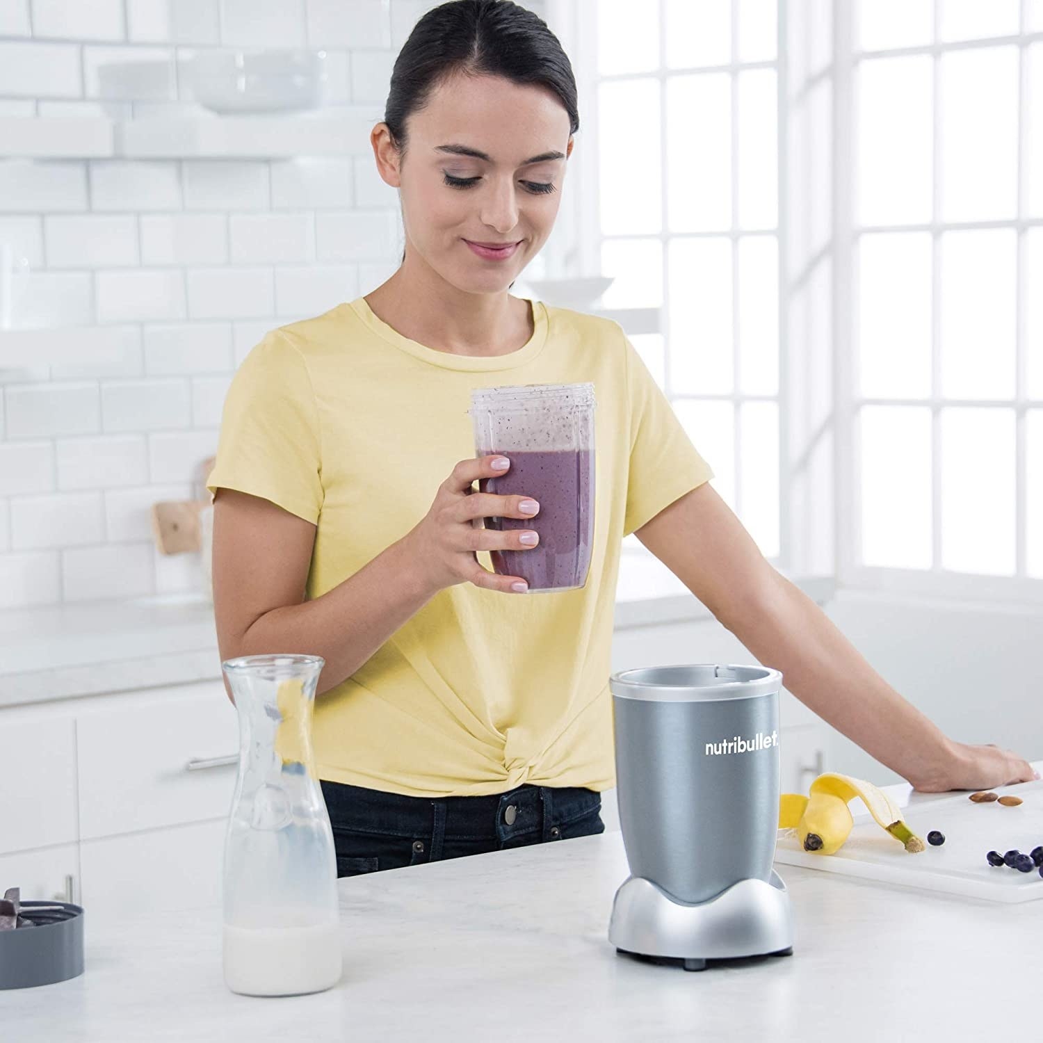 A woman holding a smoothie that she just made using the Nutribullet