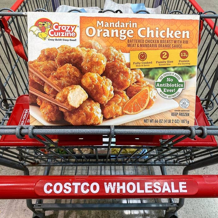 A box of frozen mandarin orange chicken in a Costco cart.