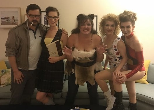 Four women dressed in nearly exact replicas of the Zoya the Destroya, Liberty Belle, The She Wolf, and Britannica costumes. One man is also wearing glasses, a swishy jacket, and has a cigarette in his mouth.