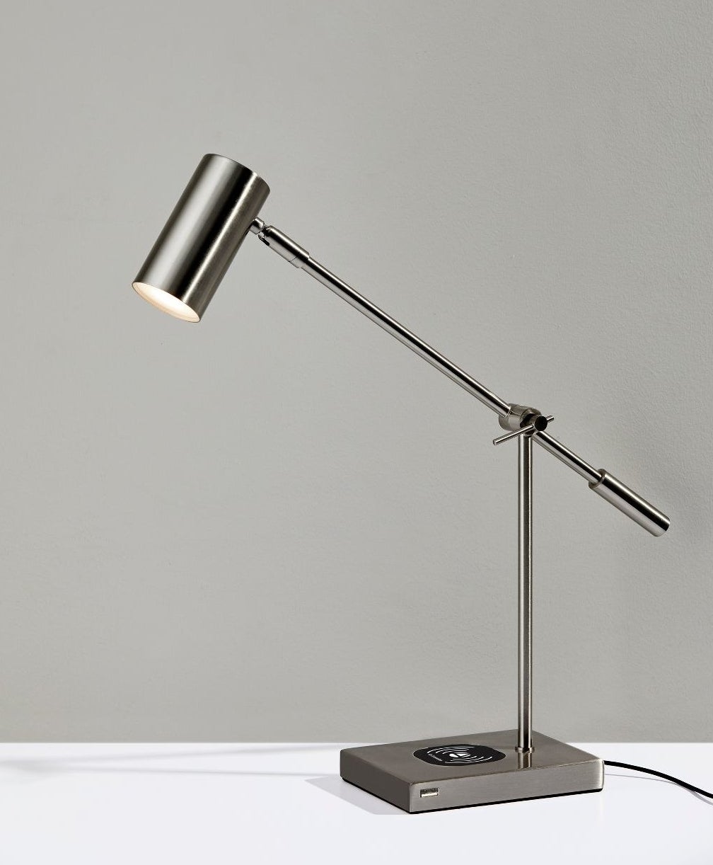 The lamp, which has an adjustable cylindrical head, an adjustable stick body, and a rectangular base with the charging station