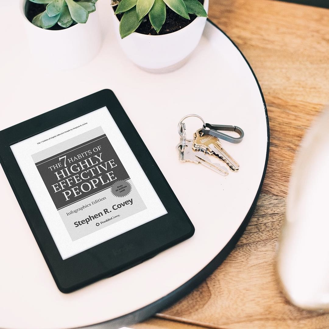 A Kindle on a table next to a set of keys