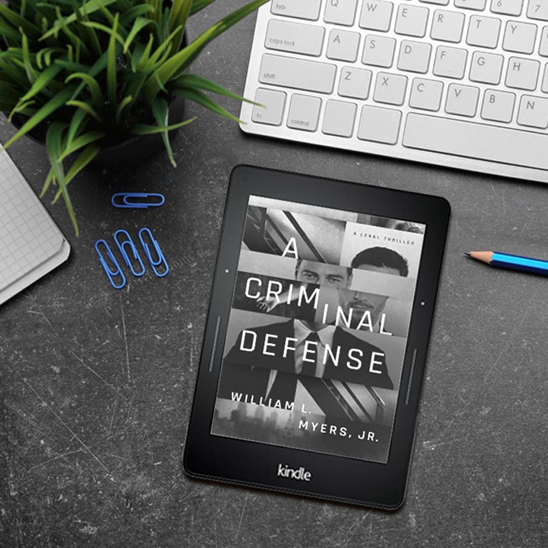 A Kindle on a desk in front of a keyboard