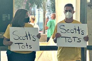 People holding up Scott's Tots signs