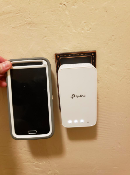 the extender with a phone held up next to it for scale, they are the same size roughly 