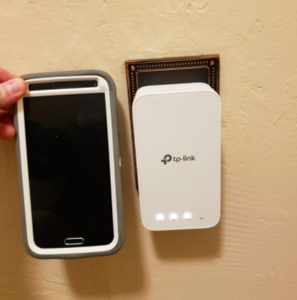the extender with a phone held up next to it for scale showing they are the same size roughly 