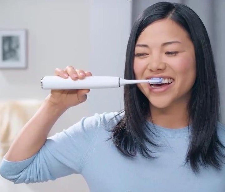 A person brushing their teeth with the toothbrush