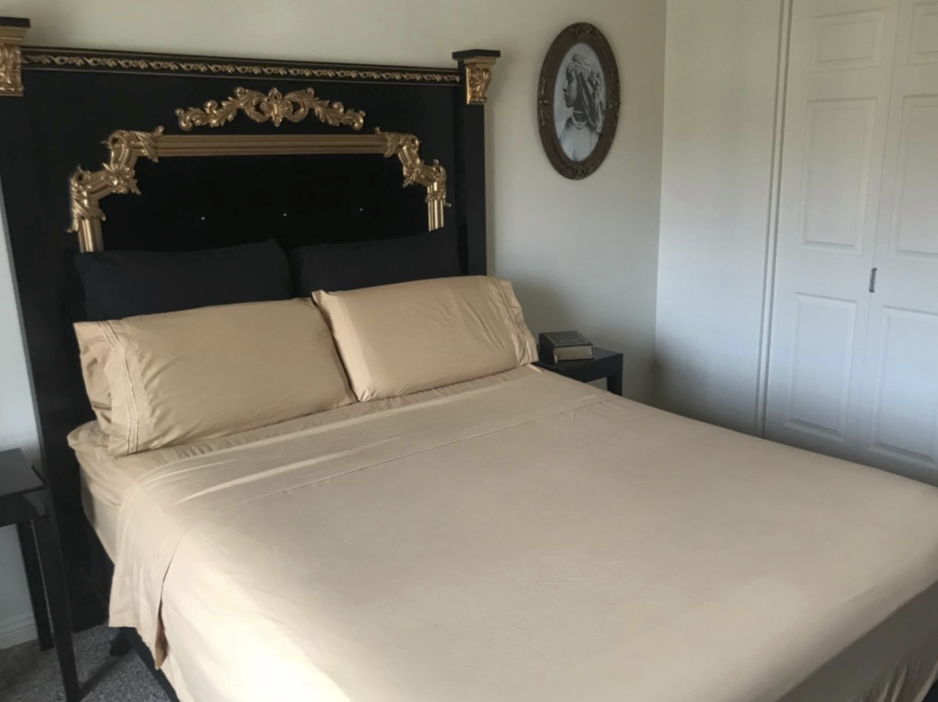 tan sheets and pillows with matching cases on a black and gold bed