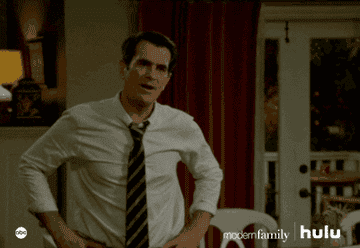 GIF of Phil from Modern family raising his fists and yelling yes