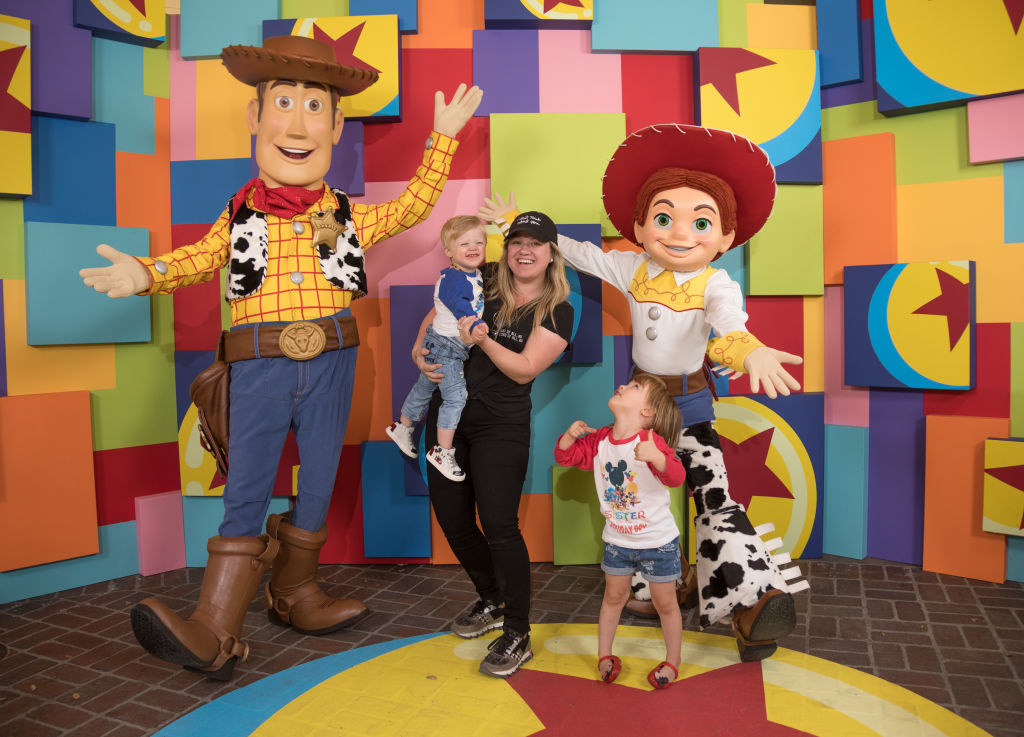 Kelly and her youngest children next to a giant Woody and Jessie from Toy Story