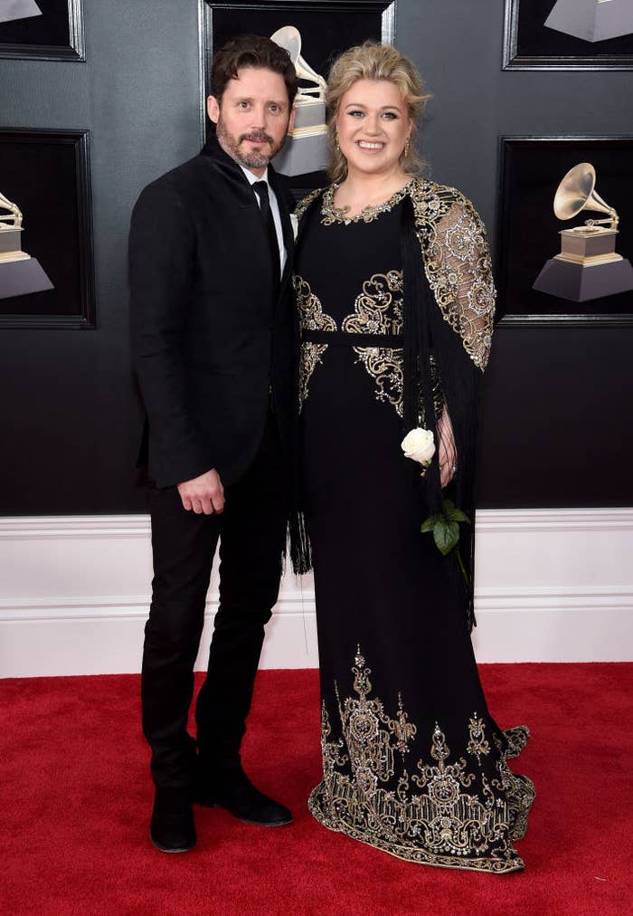 Kelly and Brandon smiling together on a red carpet