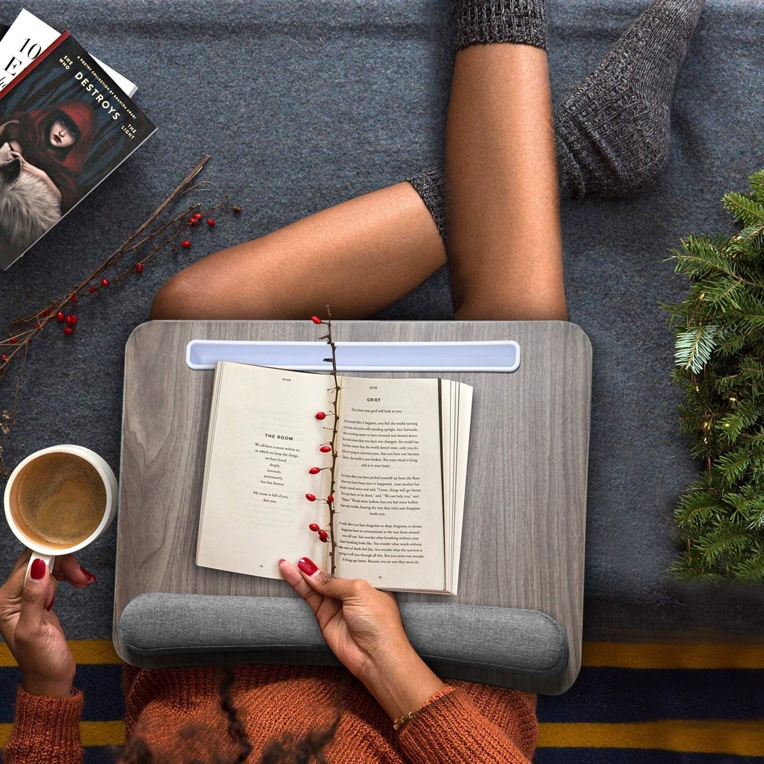 a person reading a book on their lap desk